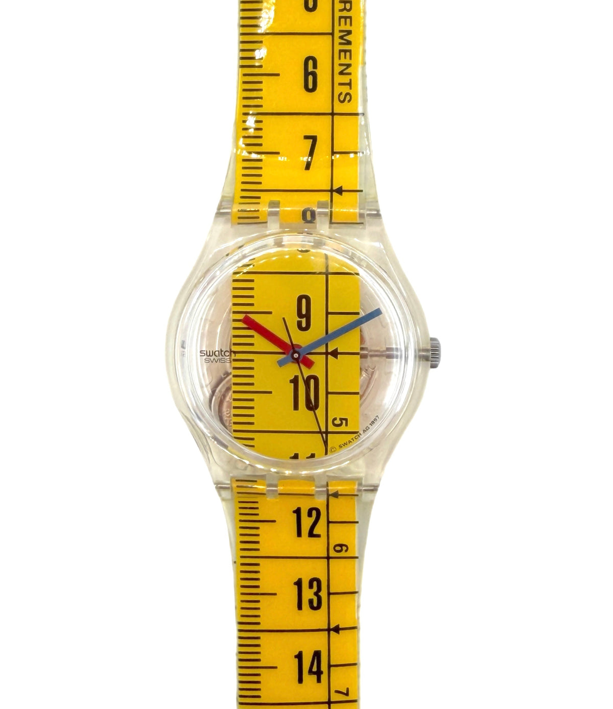 A clear plastic wristwatch with a bright yellow measuring tape strap and dial, featuring black measurement markings and colorful red and blue hands.