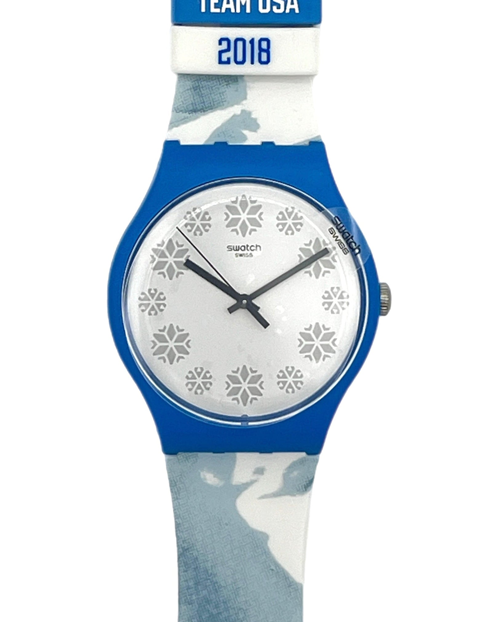 Swatch Swatch Team USA 2018 wristwatch with a blue case, white dial with snowflake patterns, and a blue and white camouflage strap.