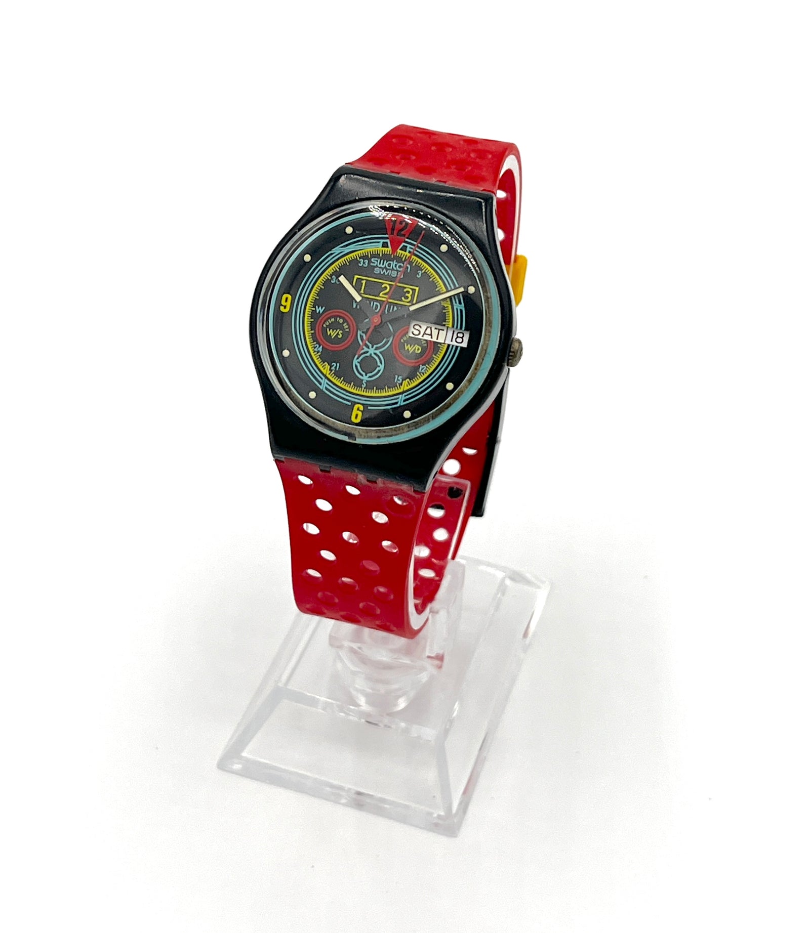 Wristwatch with a red strap on a clear stand against a white background