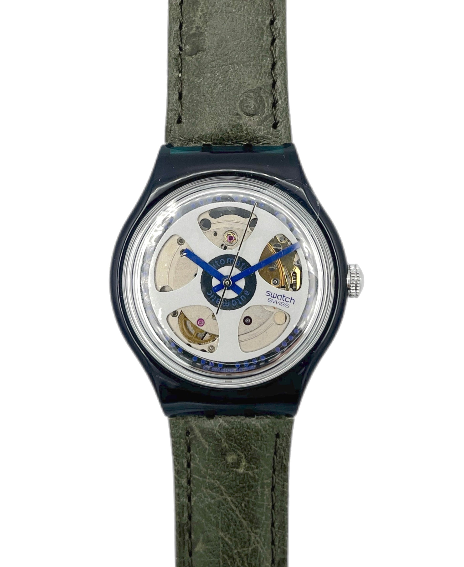 Watch with green strap and visible mechanism on a white background