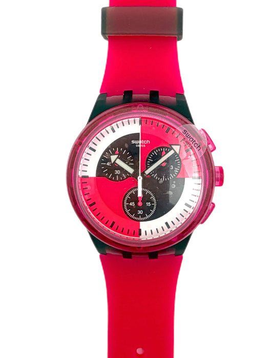 A Swatch wristwatch featuring a bright red silicone strap, a translucent pink case, and a dial with black subdials on a white background.