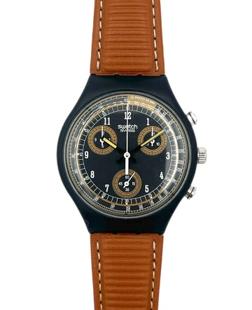 Swatch watch with brown strap and black dial on a white background