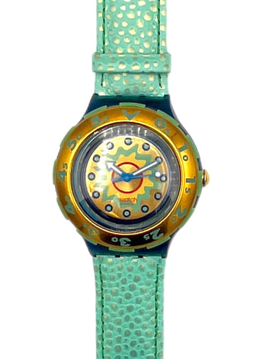 Watch with gold face and turquoise strap on a white background