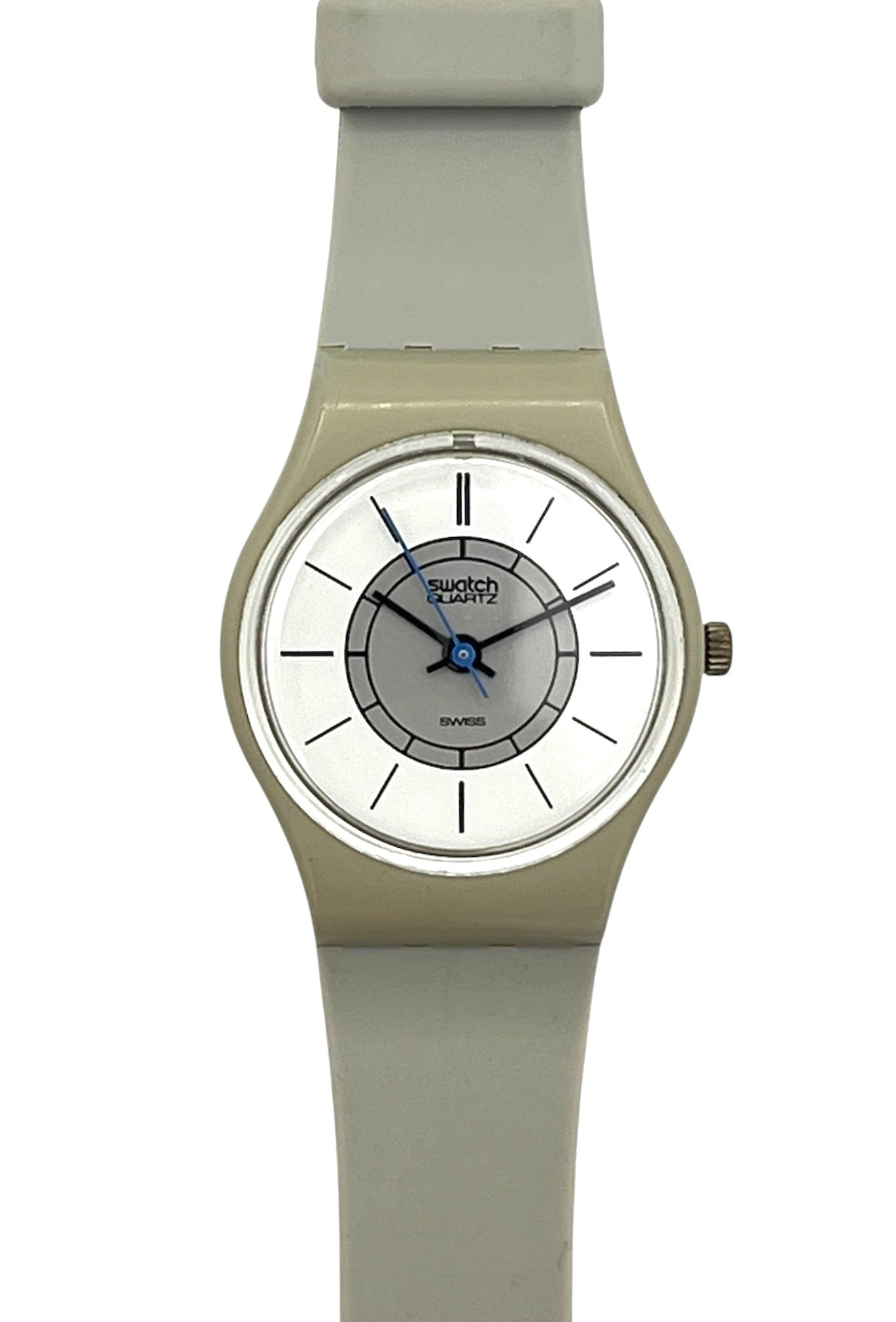 A Swatch wristwatch with a light gray silicone strap, a beige-toned case, and a white dial featuring blue hands and a gray inner ring.