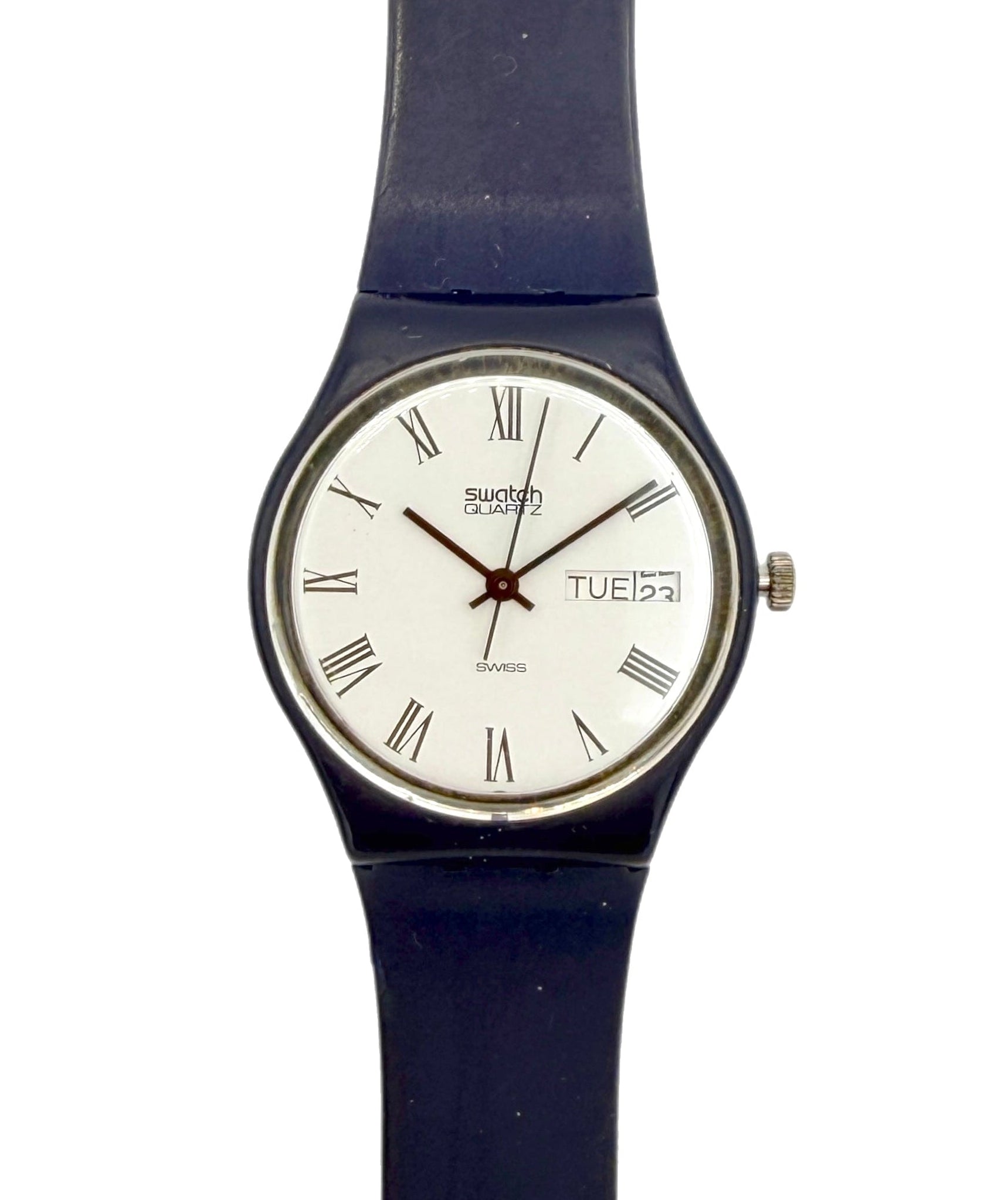 A Swatch wristwatch with a dark blue strap, a silver-tone case, and a white dial featuring black Roman numerals and a day window.