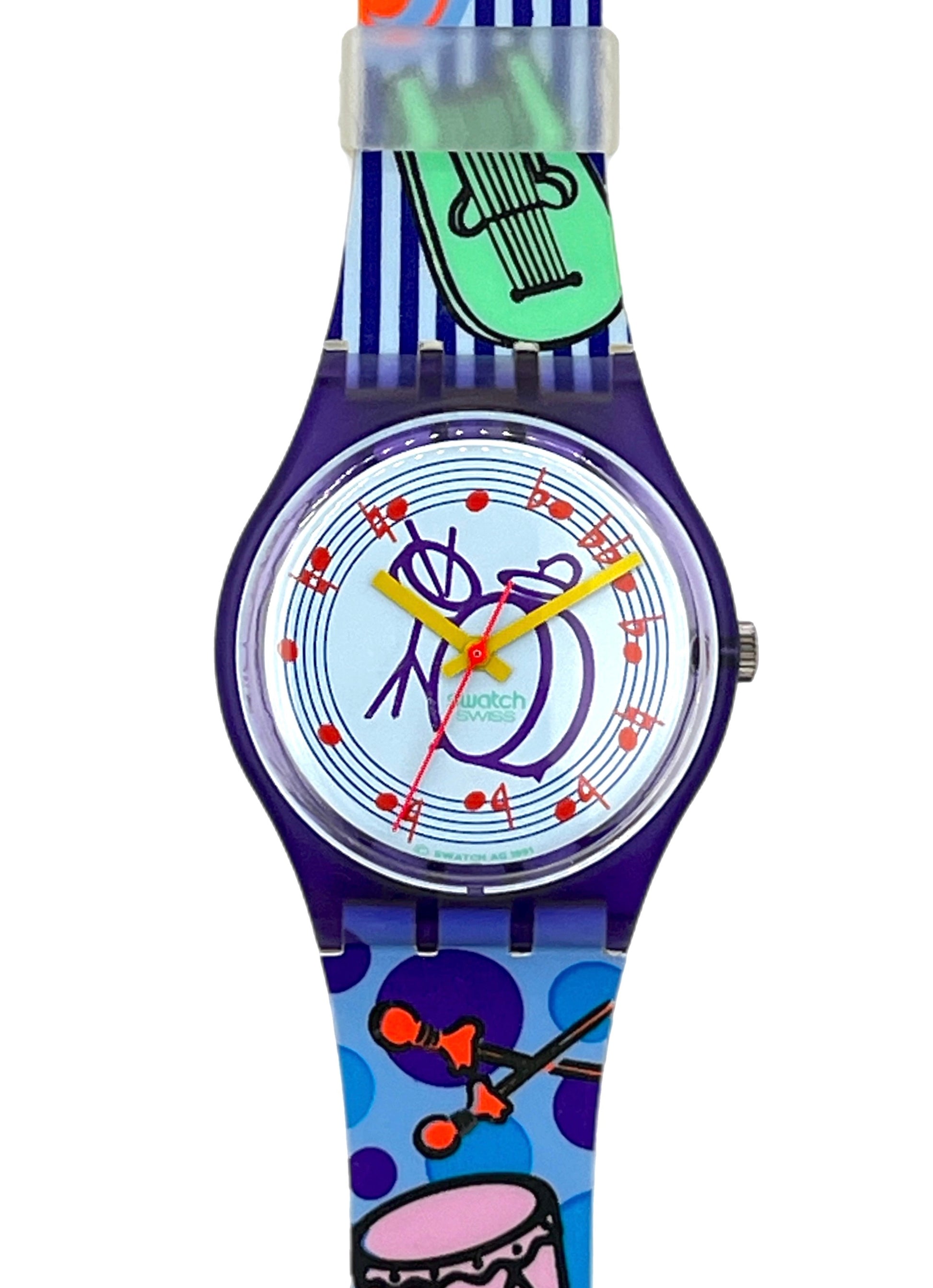 A colorful Swatch wristwatch with a purple case and a vibrant, patterned strap featuring musical instruments like a green harp, orange drumsticks, and a pink drum on a blue polka-dot background.