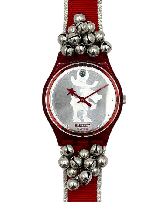 Swatch wristwatch with a red fabric strap, silver bell embellishments, and a silver dial featuring a white reindeer silhouette.