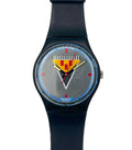 A Swatch wristwatch with a black strap and case, featuring a textured silver-gray dial with a yellow and red striped shield logo and blue accents.