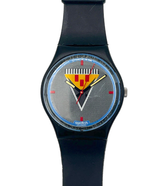 A Swatch wristwatch with a black strap and case, featuring a textured silver-gray dial with a yellow and red striped shield logo and blue accents.