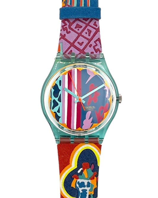 A Swatch wristwatch with a translucent mint green case and a highly colorful, patterned strap featuring red, pink, blue, and yellow designs, shown against a plain white background.