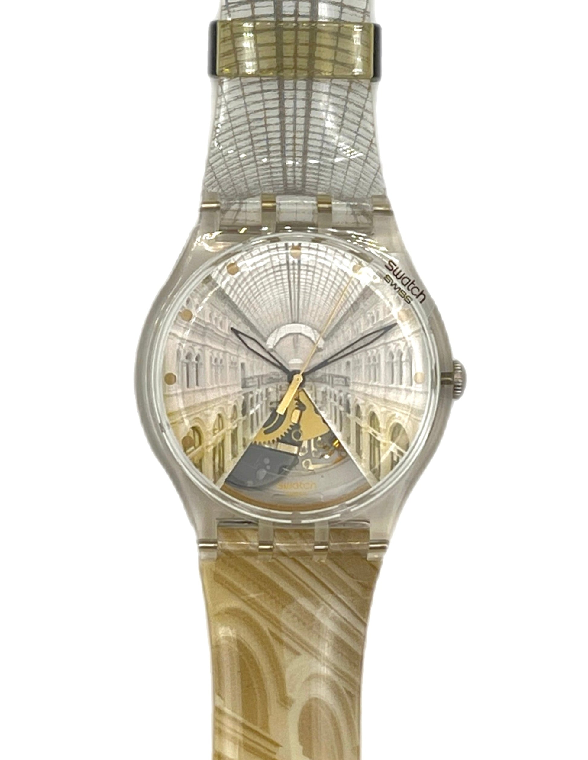 A Swatch wristwatch featuring a clear case and a strap printed with an architectural archway pattern, with a gold-toned center accent on the dial.