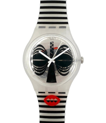 A Swatch wristwatch featuring a clear plastic case, black and white striped strap, and a unique dial with black spiral hands and a red lips logo near the bottom.