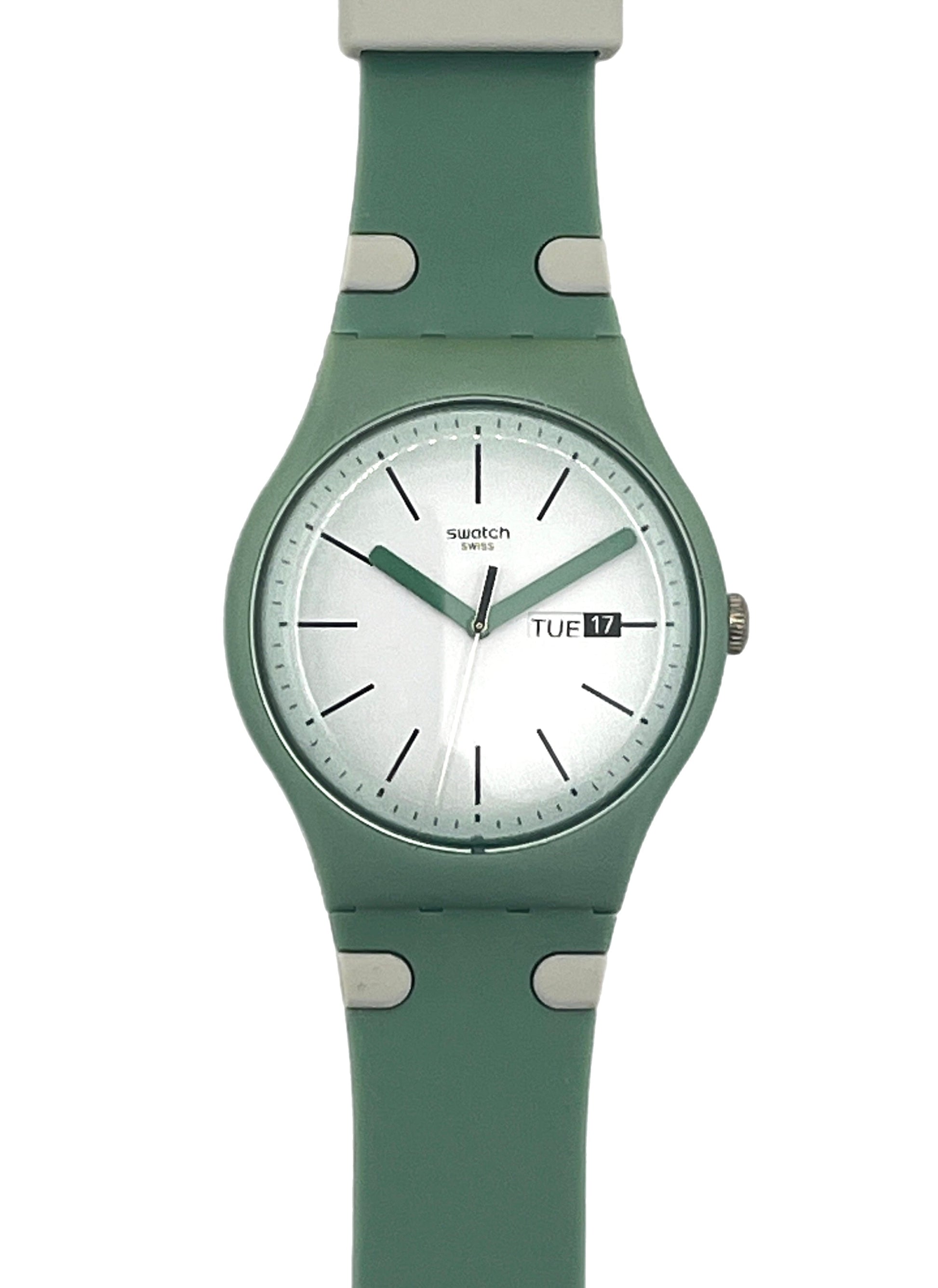 A Swatch wristwatch featuring a sage green silicone strap and matching green case with a white dial, shown against a plain white background.