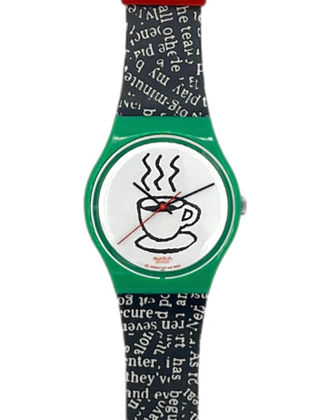 A Swatch wristwatch featuring a green case, a white dial with a black coffee cup illustration, and a black and white patterned strap.
