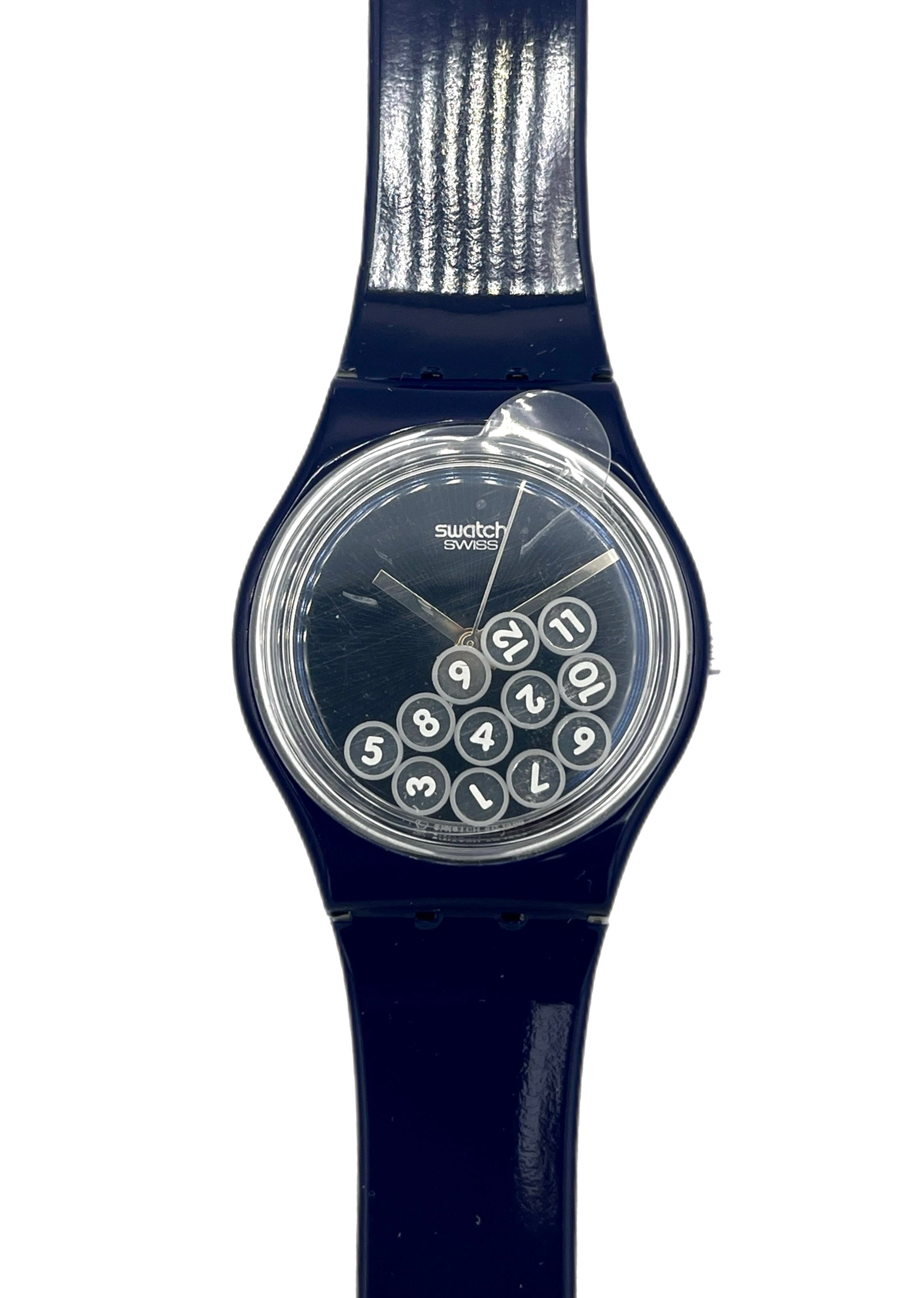Navy blue Swatch watch with a clear face showing numbers on a white background