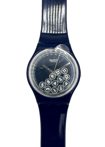 Navy blue Swatch watch with a clear face showing numbers on a white background